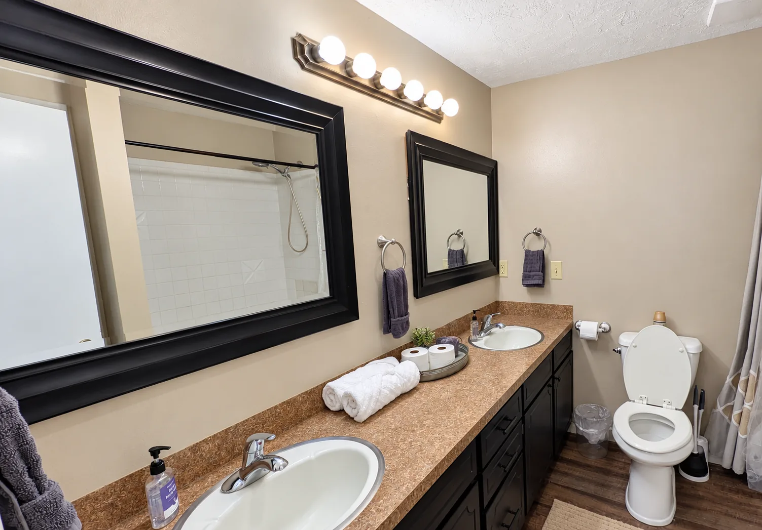 A bathroom with two sinks and neatly rolled towels